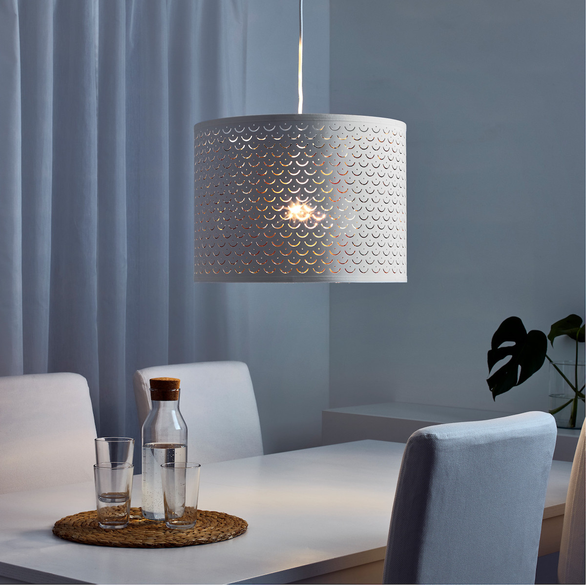 IKEA NYMÖ Lamp Shade in white hanging over a dining table.