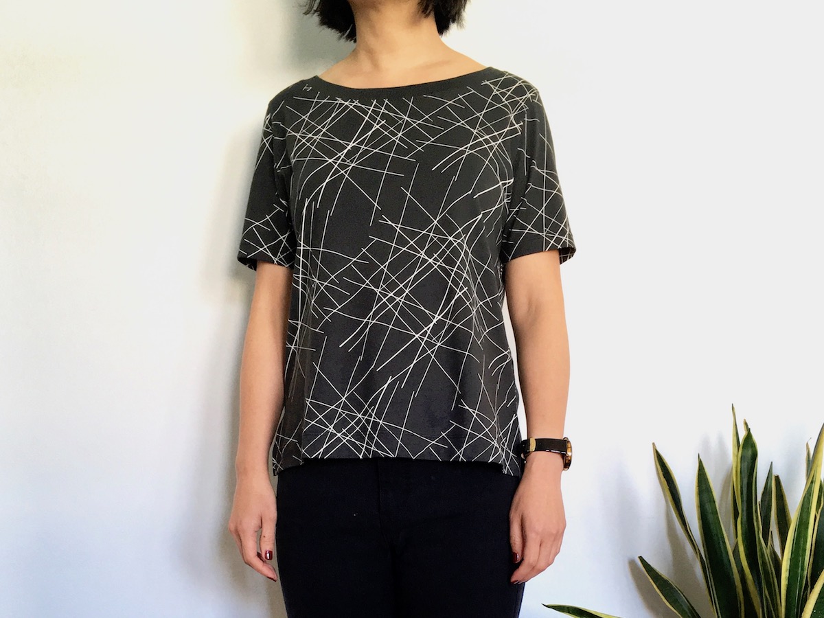 Uniqlo SPRZ Graphic Tee worn by a woman. The T=shirt is gray with white lines.