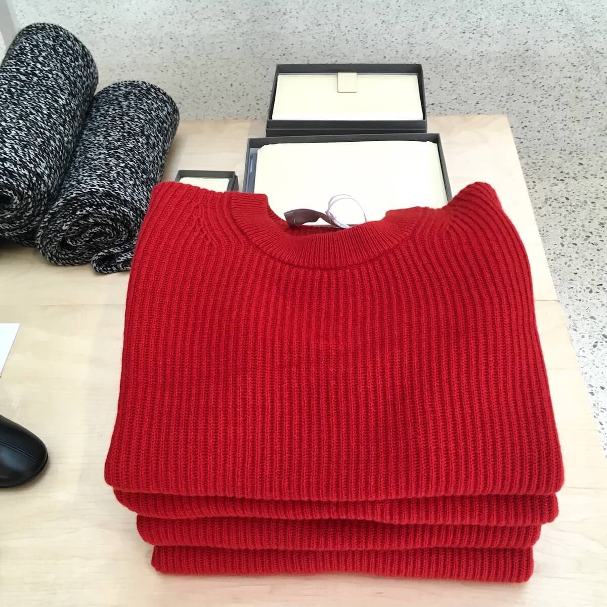 A stack of red Everlane Cashmere Rib Round Crew sweaters