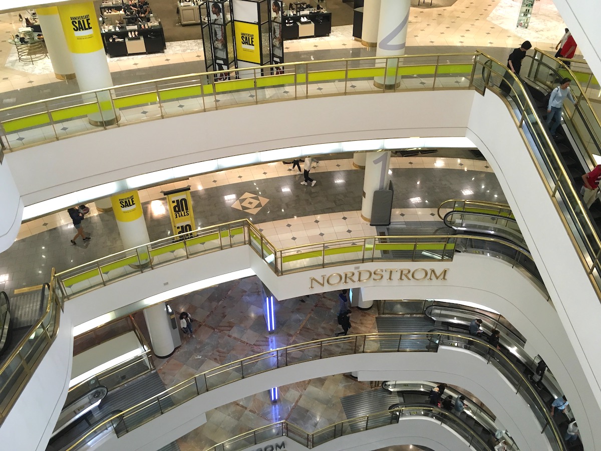 The Thrill of the Nordstrom Anniversary Sale is Gone: The Nordstrom store inside a mall. The photo is taken from above looking down on several levels of the store inside a mall, with escalators between each floor.