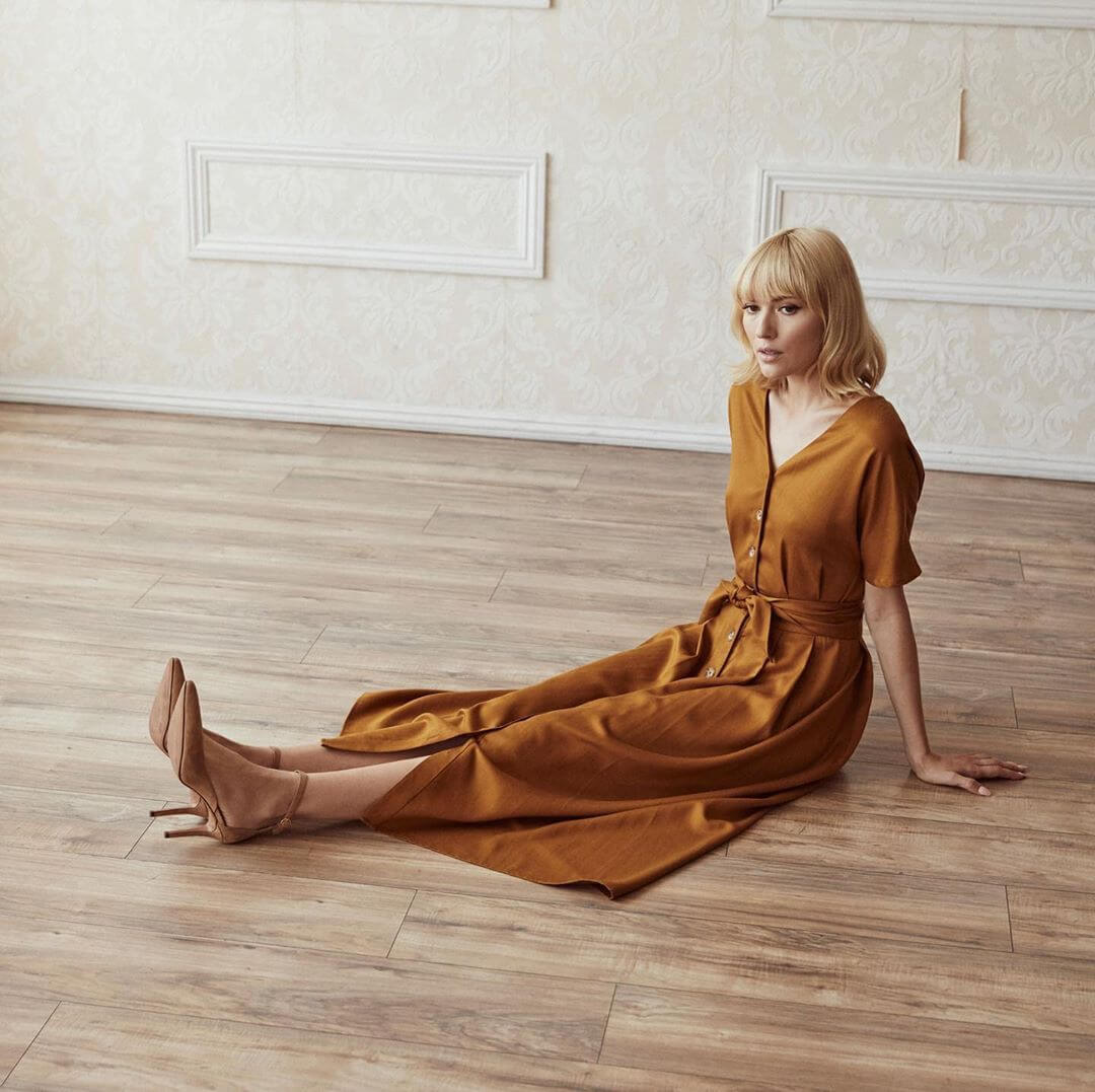 Vetta two-piece midi dress in yellow as worn by a model, a white woman, sitting on the floor.