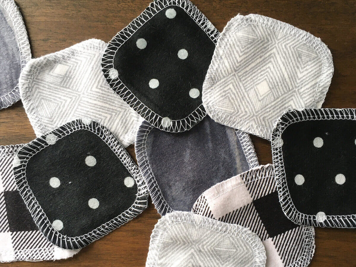 Reusable cotton facial rounds by Marley's Monsters in a variety of black and white prints on a wood background.