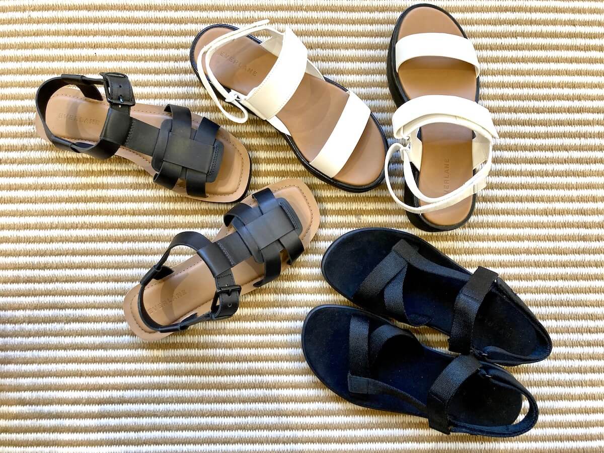 3 pairs of Everlane sandals on a rug