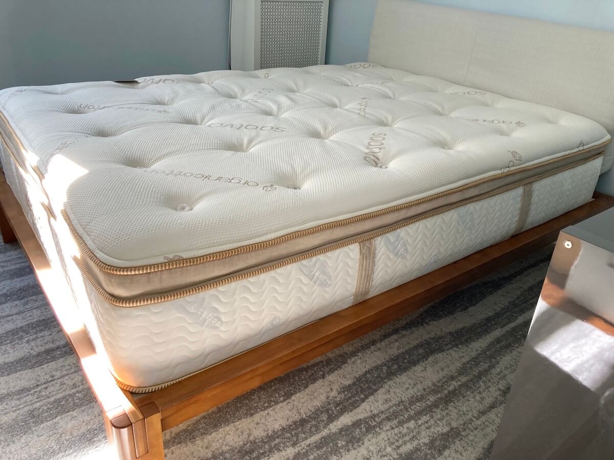 The Saatva HD mattress on a bed frame, as viewed from the side.