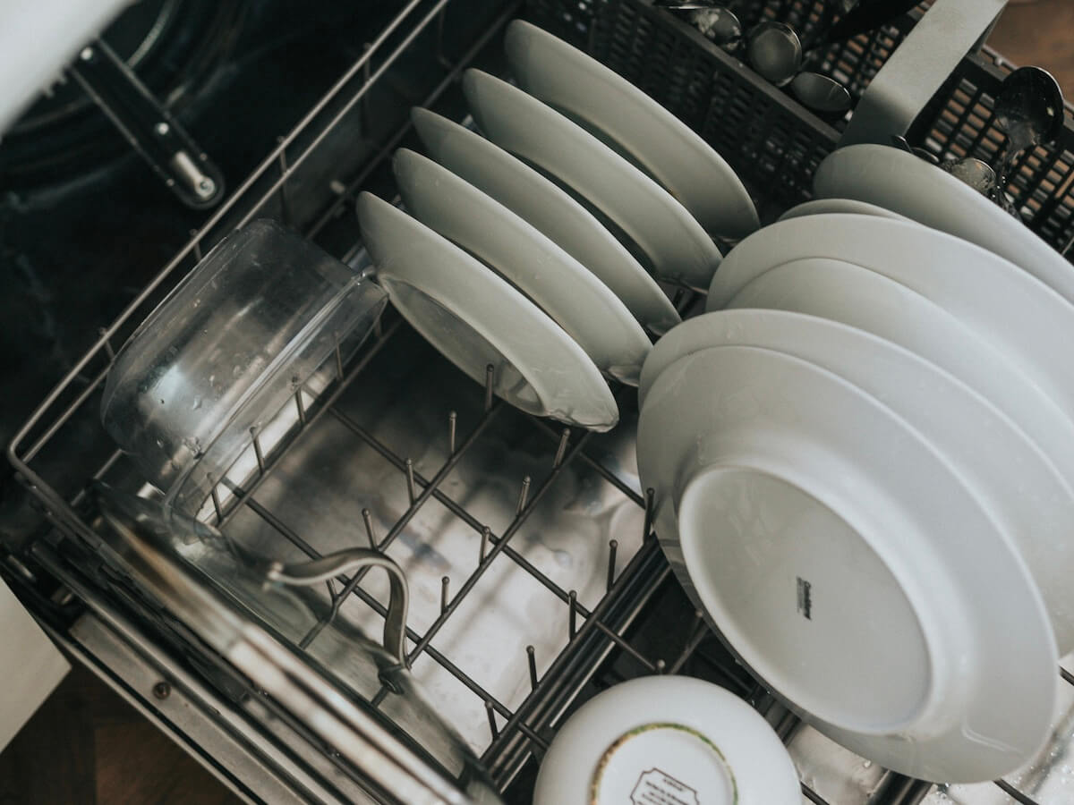 White dishes in a dishwasher's bottom rack