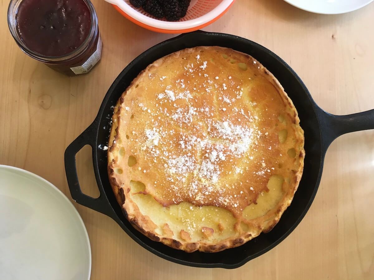 A cast iron pan with a dutch baby pancake